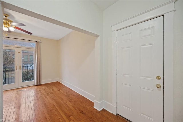 entryway with light hardwood / wood-style floors, french doors, and ceiling fan