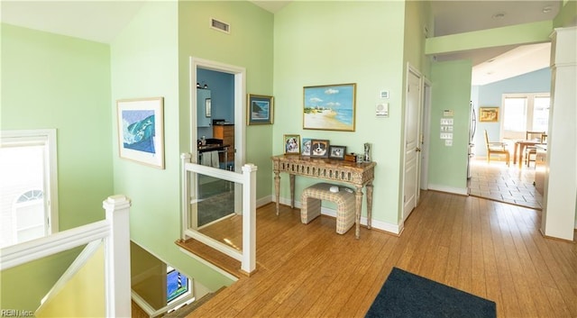 hallway featuring lofted ceiling and light hardwood / wood-style floors