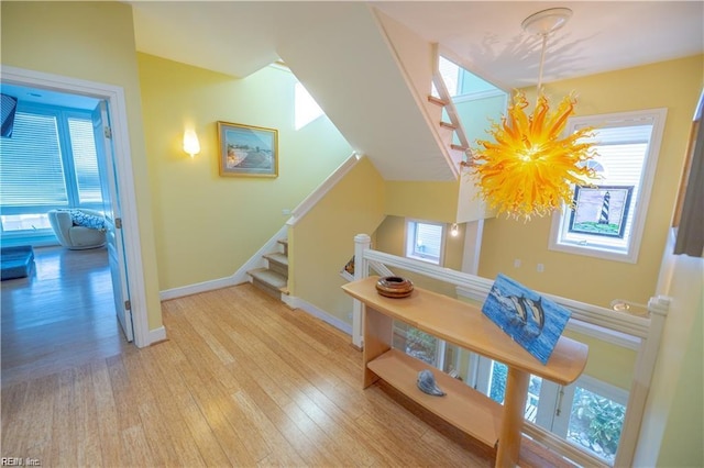 staircase featuring wood-type flooring and an inviting chandelier