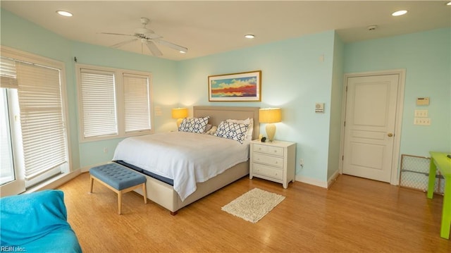 bedroom featuring multiple windows, light hardwood / wood-style floors, and ceiling fan