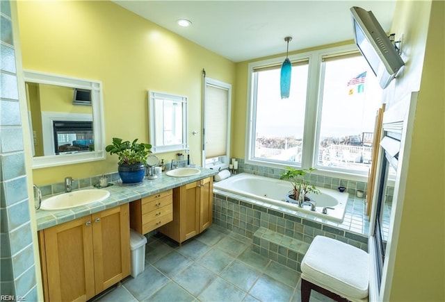 bathroom with vanity, tile patterned flooring, and tiled bath