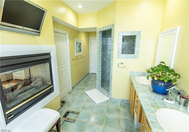 bathroom featuring vanity, tile patterned floors, and tiled shower