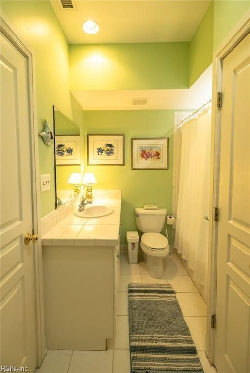 bathroom featuring vanity, tile patterned floors, and toilet