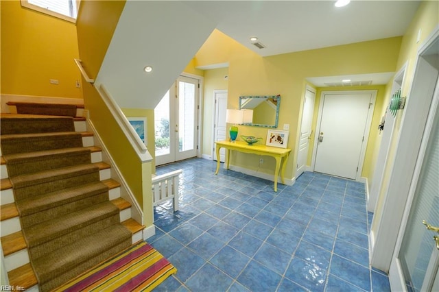 entryway with dark tile patterned flooring and french doors