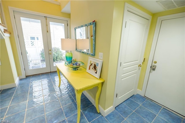 entryway with french doors and dark tile patterned floors