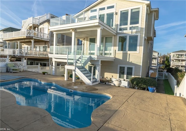 back of property with a fenced in pool and a patio