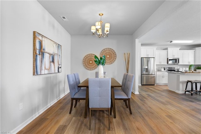 dining room with an inviting chandelier and dark wood-type flooring