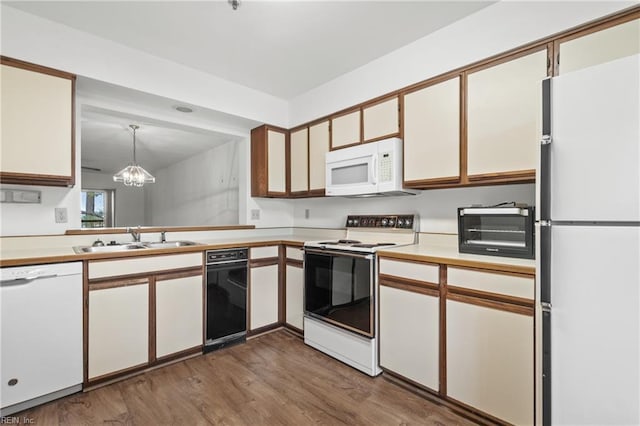 kitchen featuring sink, white cabinetry, decorative light fixtures, dark hardwood / wood-style flooring, and white appliances