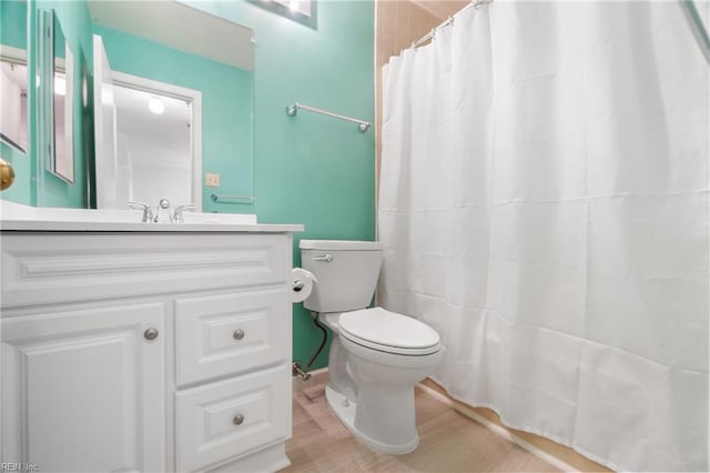 bathroom featuring vanity, curtained shower, toilet, and hardwood / wood-style flooring