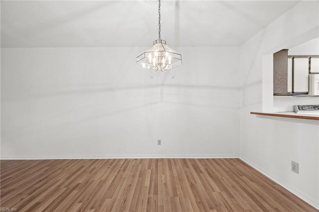 unfurnished dining area featuring hardwood / wood-style flooring and a chandelier