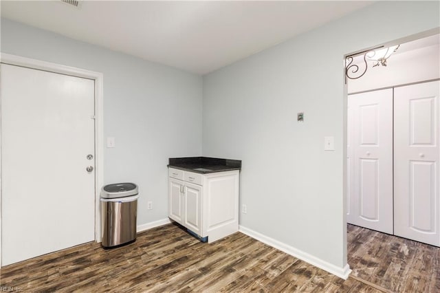 laundry room with dark wood-type flooring