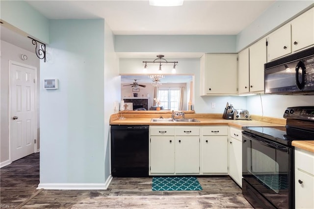 kitchen featuring dark hardwood / wood-style flooring, sink, black appliances, and white cabinets