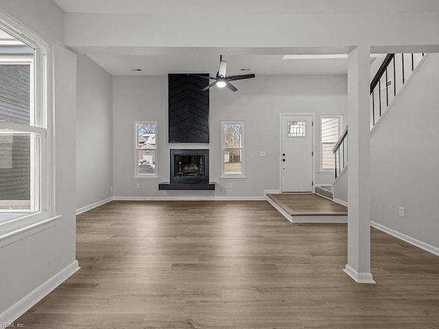 unfurnished living room with hardwood / wood-style floors, a fireplace, and ceiling fan