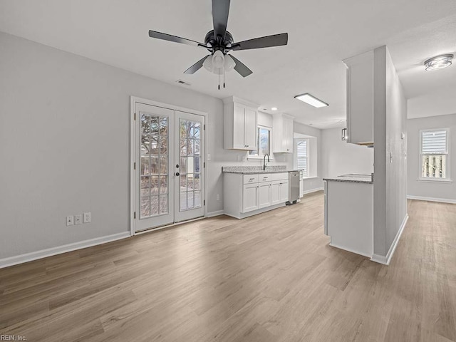 unfurnished living room with french doors, ceiling fan, sink, and light wood-type flooring