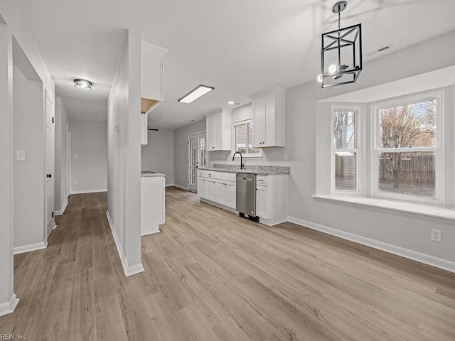 kitchen featuring stainless steel dishwasher, light hardwood / wood-style floors, sink, and white cabinets