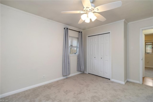 unfurnished bedroom with crown molding, light colored carpet, a closet, and ceiling fan