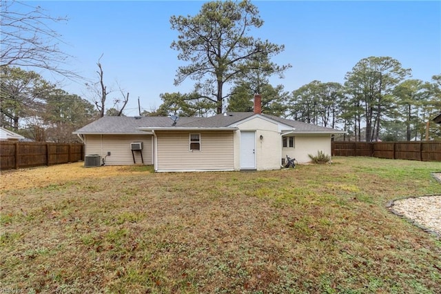 back of house with central air condition unit and a lawn