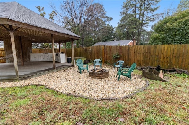 view of yard with a wooden deck and a fire pit