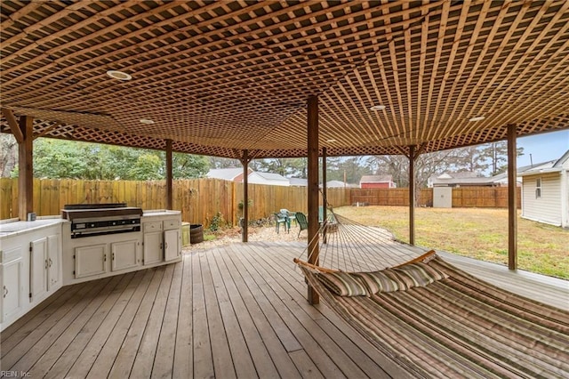 wooden terrace with an outdoor kitchen and area for grilling