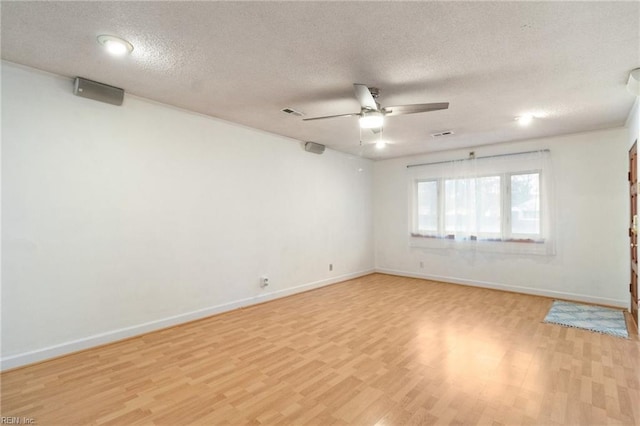 empty room featuring ceiling fan, light hardwood / wood-style flooring, and a textured ceiling