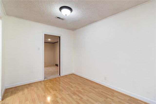 spare room with hardwood / wood-style floors and a textured ceiling