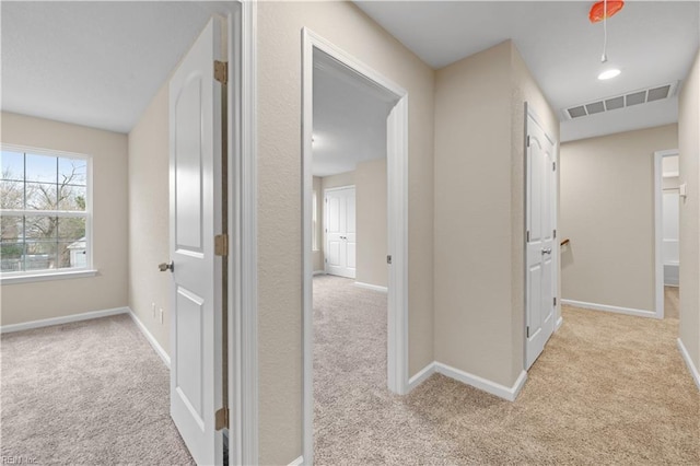 hall featuring light colored carpet