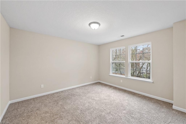 carpeted spare room featuring a textured ceiling