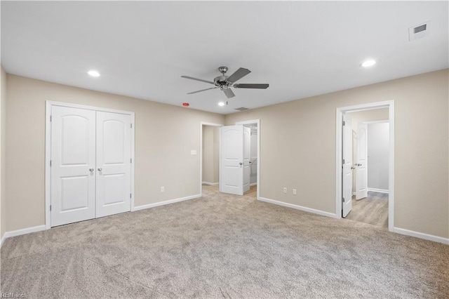 unfurnished bedroom featuring light colored carpet, a closet, and ceiling fan