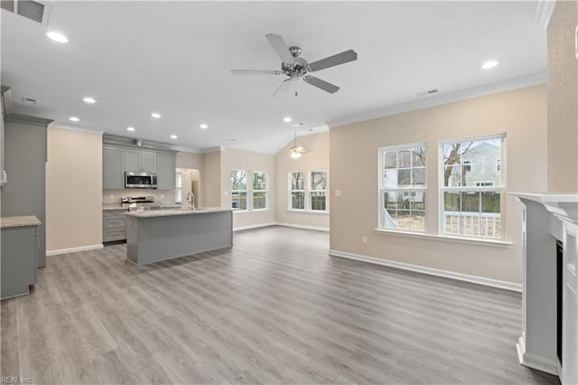 living room featuring sink, light hardwood / wood-style flooring, and ornamental molding