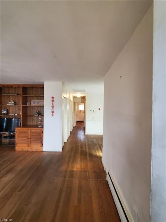 hallway featuring a baseboard heating unit and dark hardwood / wood-style flooring