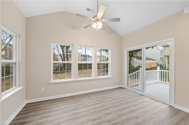 empty room with ceiling fan, lofted ceiling, and light hardwood / wood-style floors