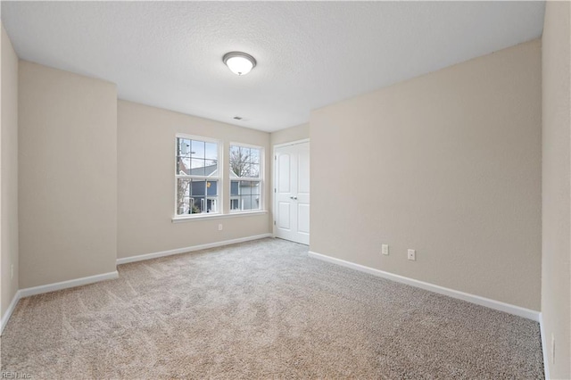 spare room featuring carpet floors and a textured ceiling