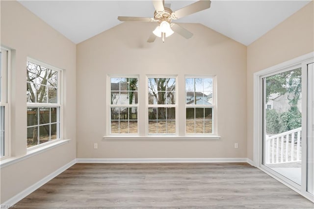 unfurnished sunroom featuring ceiling fan, a healthy amount of sunlight, and lofted ceiling