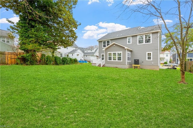 rear view of house featuring a yard