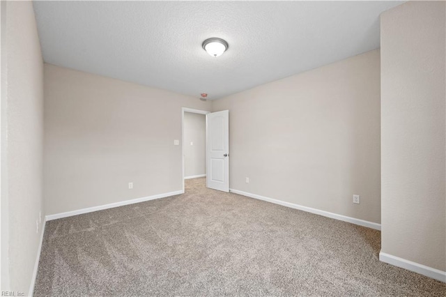 carpeted empty room featuring a textured ceiling