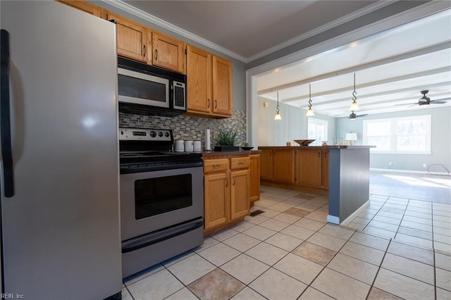 kitchen featuring light tile patterned floors, ornamental molding, pendant lighting, stainless steel appliances, and decorative backsplash