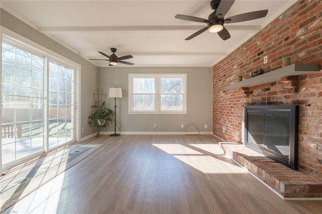 unfurnished living room with a fireplace, light hardwood / wood-style flooring, beamed ceiling, and a healthy amount of sunlight