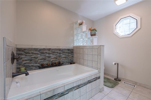 bathroom with tiled bath and tile patterned flooring