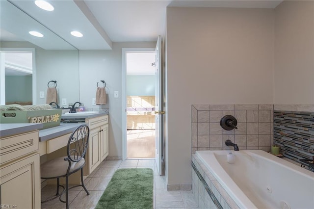 bathroom featuring vanity, tile patterned flooring, and tiled bath