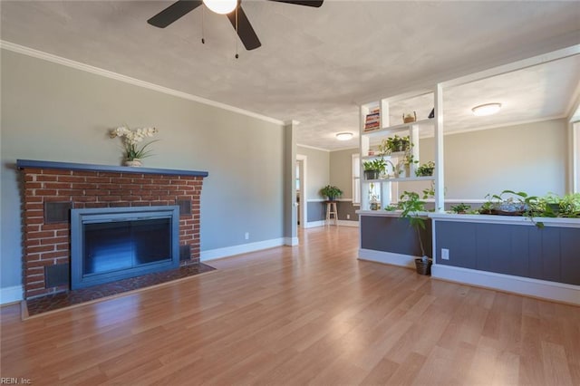 unfurnished living room with crown molding, a brick fireplace, ceiling fan, and light hardwood / wood-style flooring