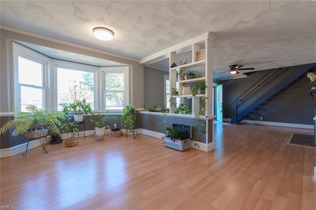 unfurnished room featuring crown molding, wood-type flooring, and ceiling fan