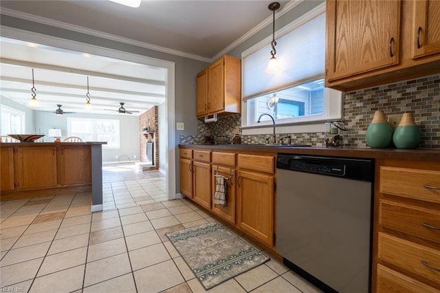 kitchen featuring light tile patterned flooring, sink, hanging light fixtures, ornamental molding, and stainless steel dishwasher