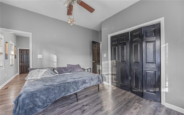 bedroom with visible vents, ceiling fan, baseboards, and wood finished floors