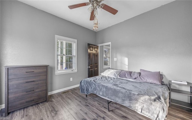 bedroom with ceiling fan, baseboards, and wood finished floors