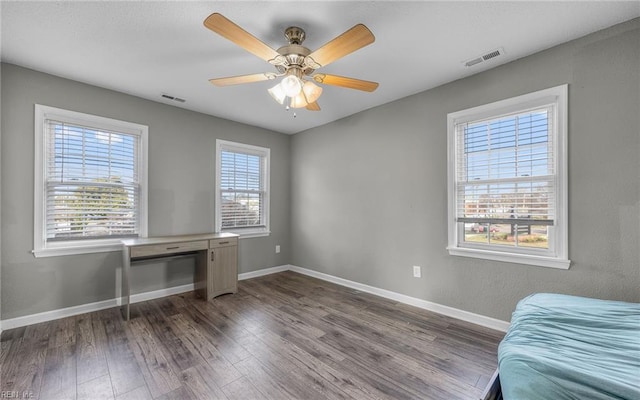 bedroom with dark wood-type flooring, visible vents, ceiling fan, and baseboards