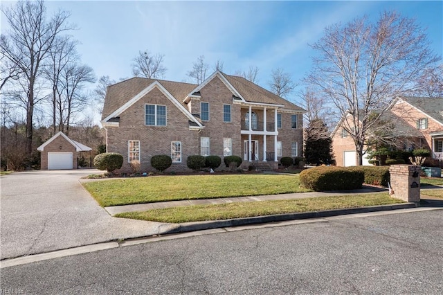 view of front of home with a garage, an outdoor structure, and a front yard