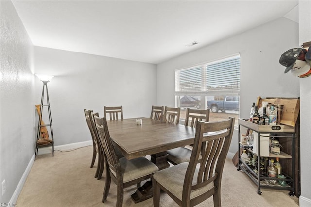 dining area featuring light carpet