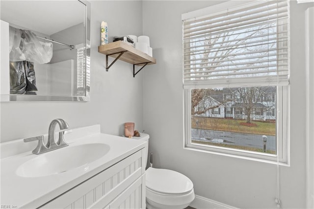 bathroom with plenty of natural light, toilet, and vanity