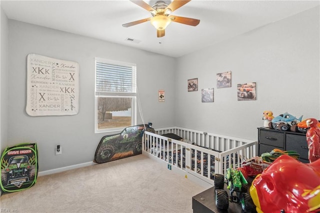 carpeted bedroom with a nursery area and ceiling fan