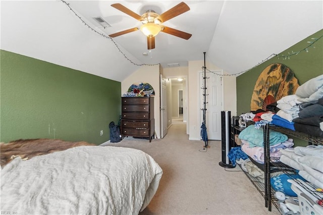 bedroom with lofted ceiling, light colored carpet, connected bathroom, and ceiling fan